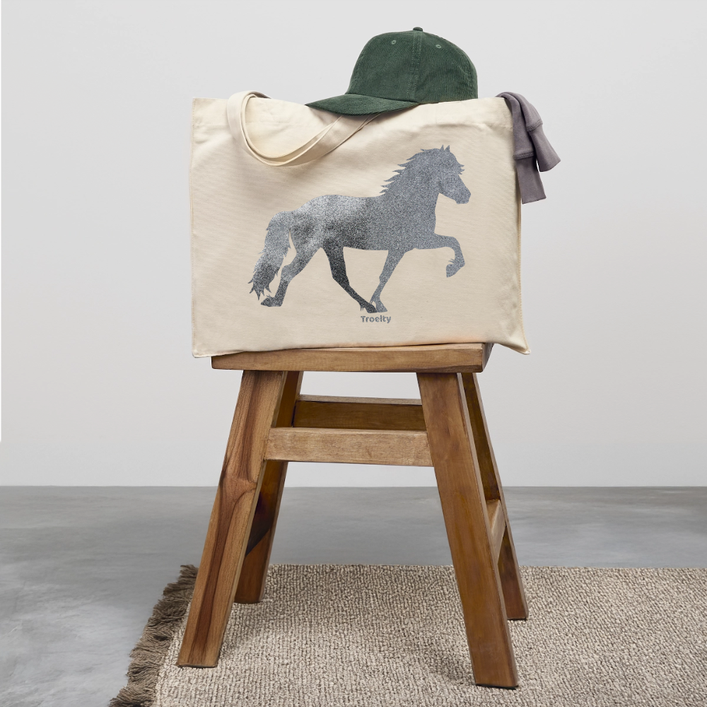 Helle Tasche mit langen Henkeln und Tölter in Glitzer, die auf einem Hocker abgestellt ist