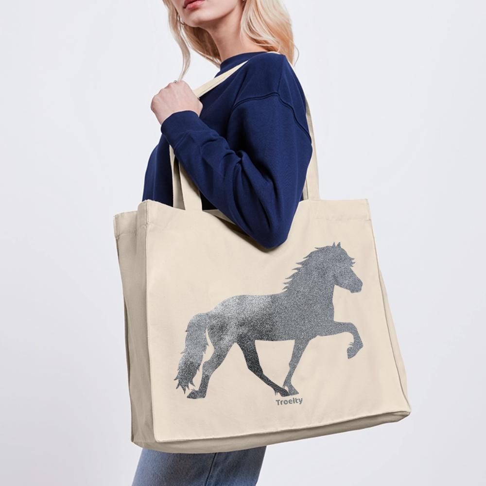 Frau, die eine helle Tasche mit langen Henkeln und Tölter in Glitzer trägt